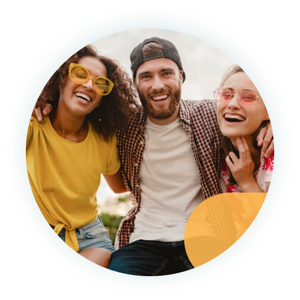 Three friends wearing colorful sunglasses smile and lean in close, enjoying time together outdoors.